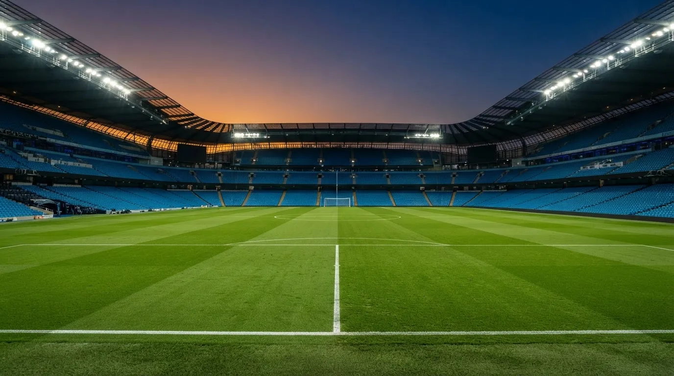 An empty football stadium with floodlight masts at dusk