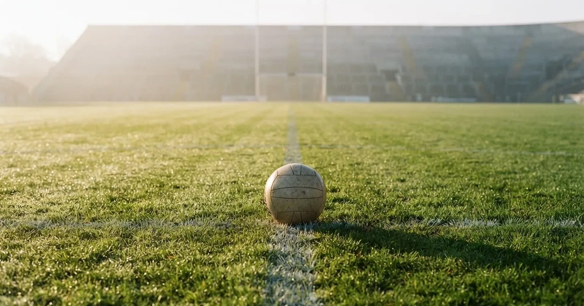 A ball on the centre spot of a grass pitch in morning light