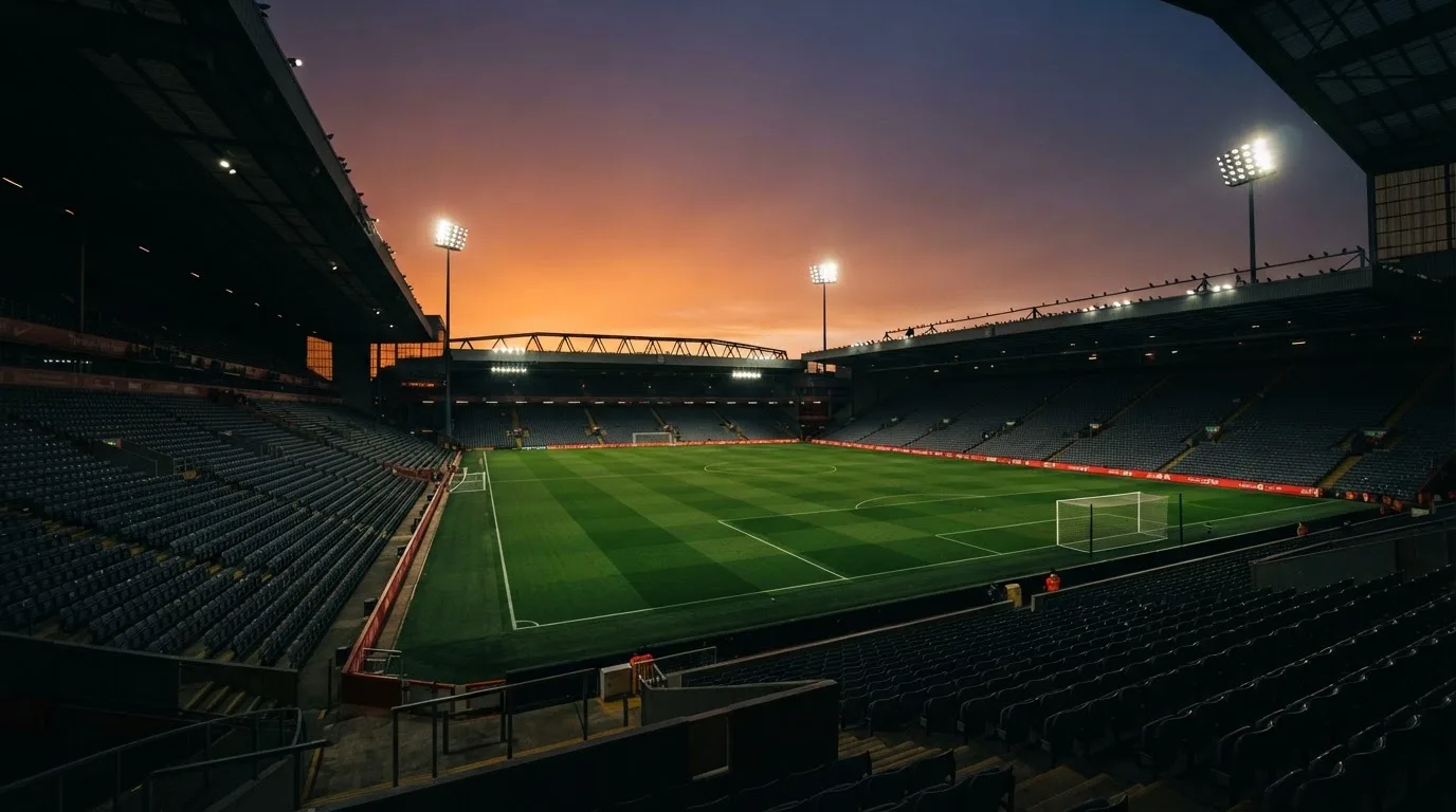 An empty football stadium with floodlight masts at dusk