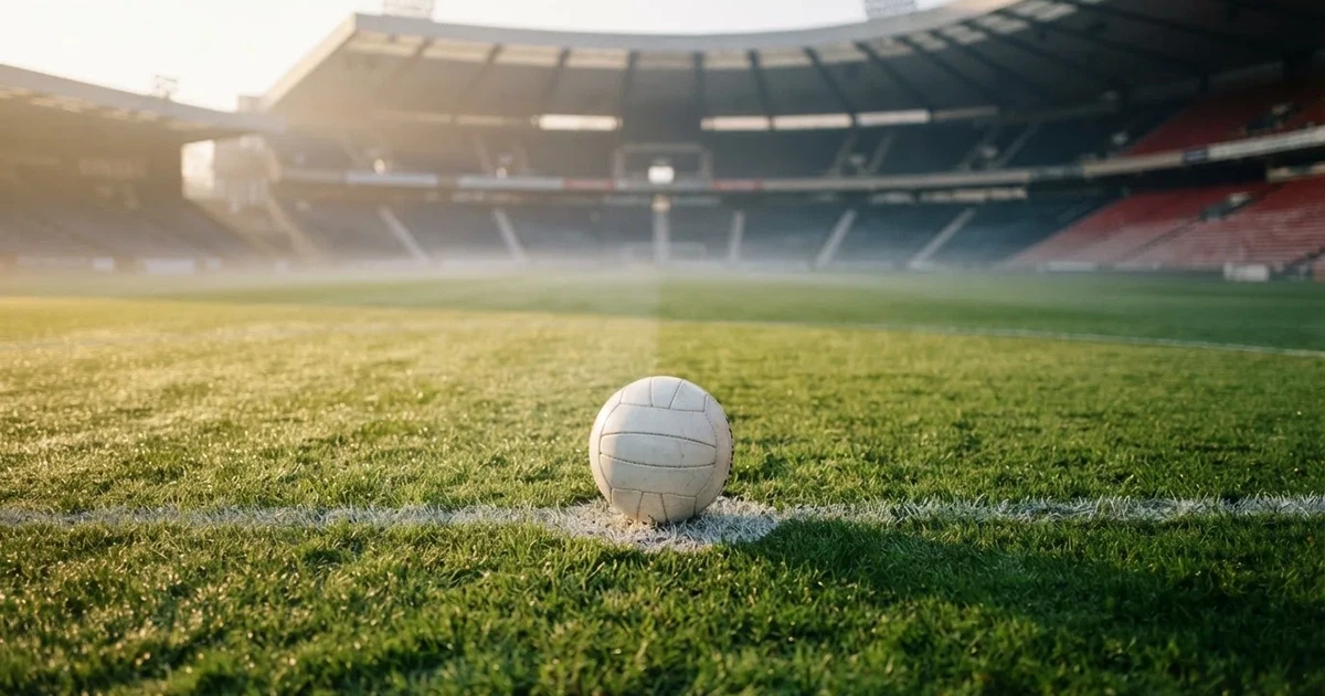 A ball on the centre spot of a grass pitch in morning light