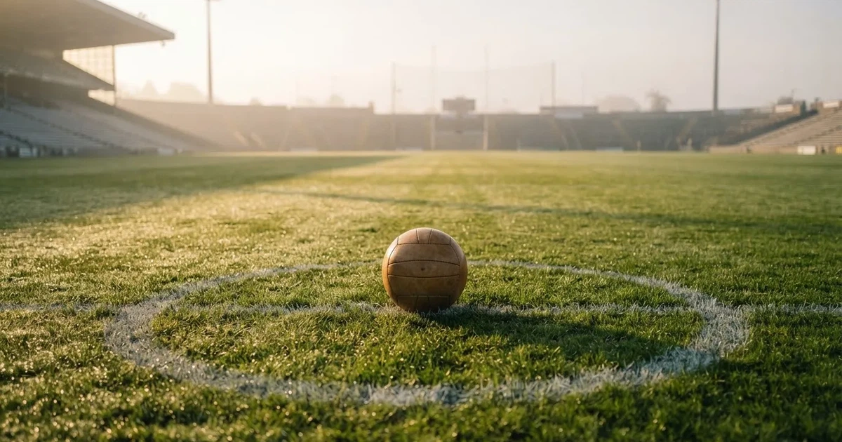 A ball on the centre spot of a grass pitch in morning light