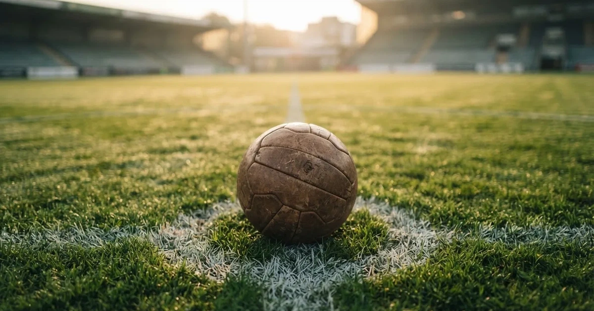 A ball on the centre spot of a grass pitch in morning light